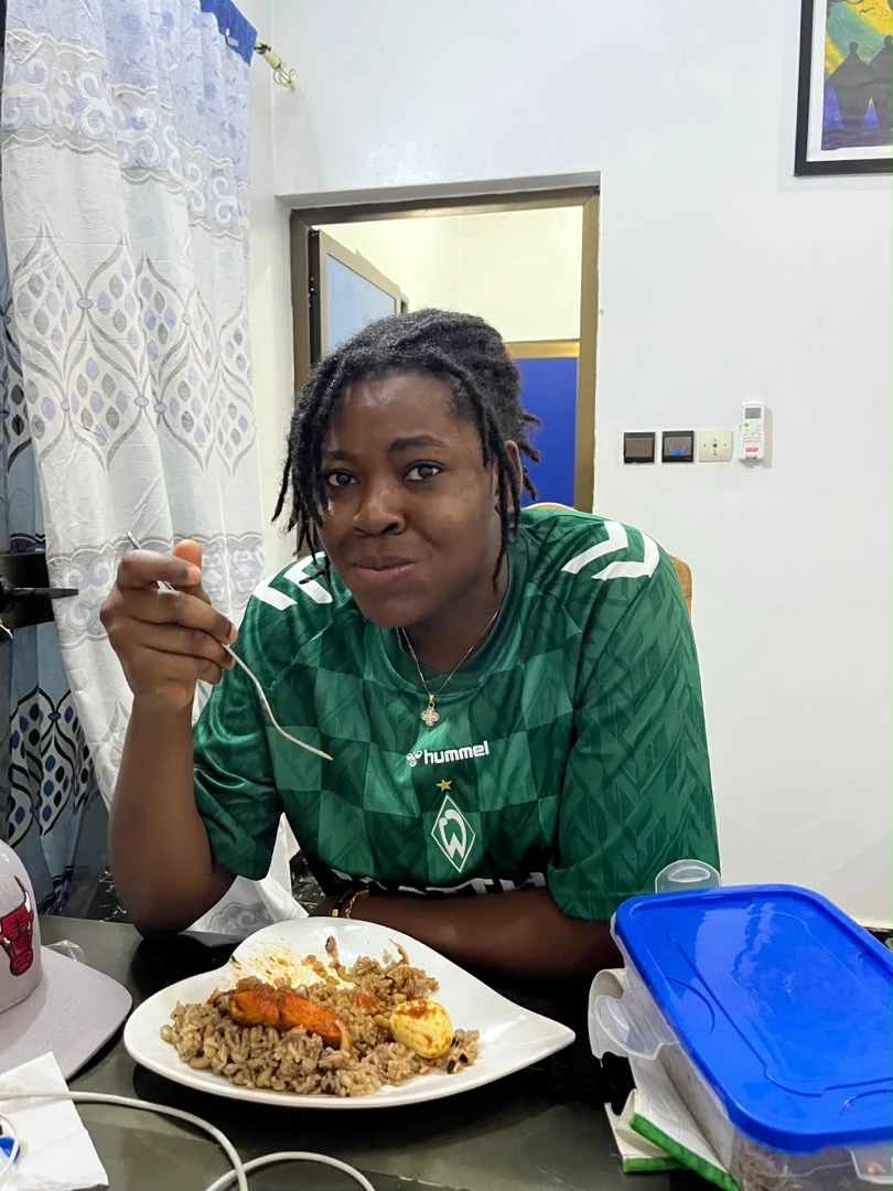 Sika Reine à table devant son assiette